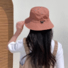 Jeune fille de dos porte un bob imperméable