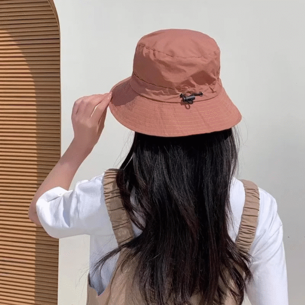 Jeune fille de dos porte un bob imperméable