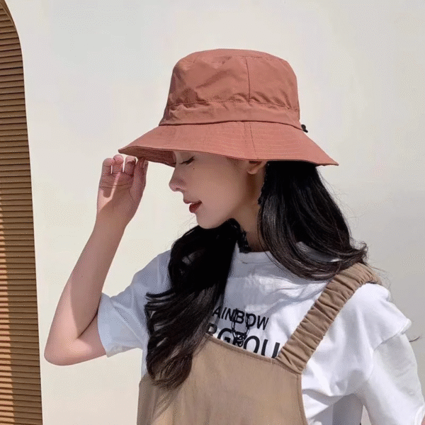 Jeune fille de profil porte un bob imperméable