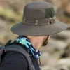 Un homme de dos porte un bob ficelle pour se protéger du soleil dans un décor de nature flouté