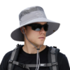 Homme aventurier avec des lunettes et un grand bob couleur gris sur fond blanc