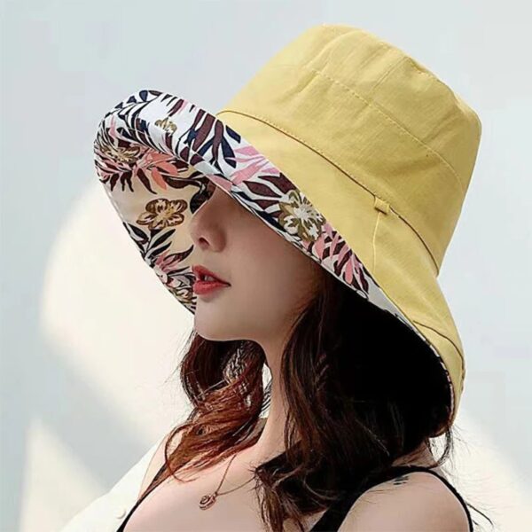 Une femme porte un bob chapeau élégant jaune sur un décor clair et lumineux