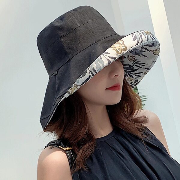 Une femme porte un bob chapeau élégant noir sur un décor clair et lumineux