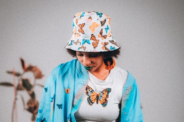 Une-jeune-femme-tenue-décontractée-porte-un-bob-chapeau-avec-des-papillons-imprimés-dessus