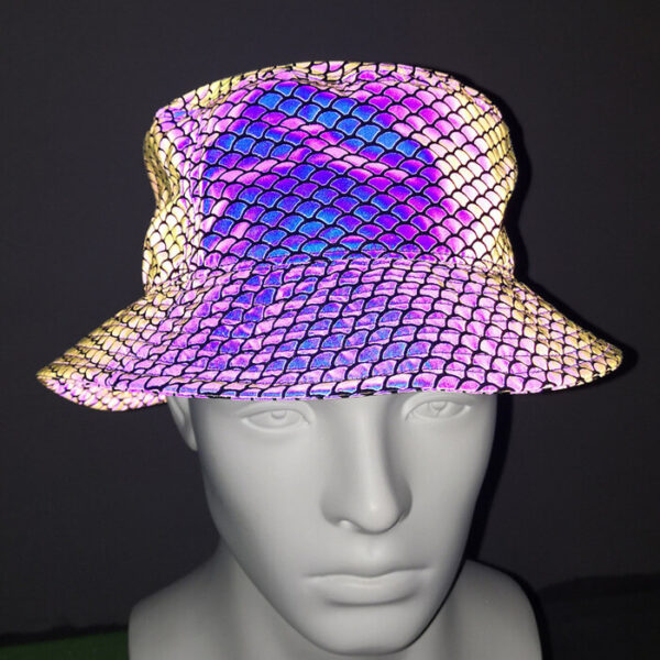 Une tête de mannequin en plastique, porésenteun chapeau bob avec des motifs réfléchissants en forme d'écailles sur un tissu noir avec un arrière plant sombre