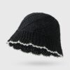 Un bob en paille couleur noir sur un décor blanc