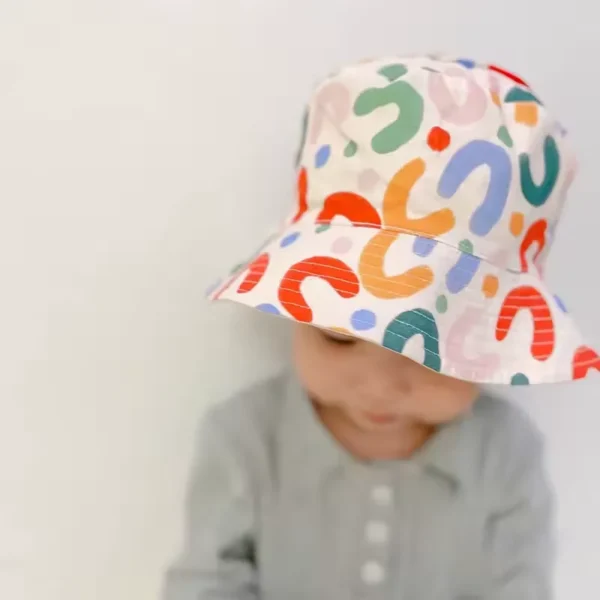 Un bébé porte un bob chapeau adorable sur un fond clair