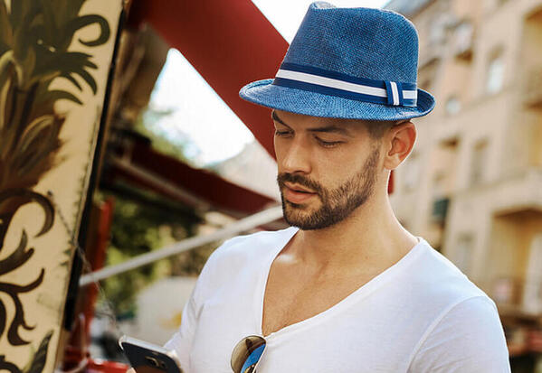 Homme-style-contemporain-avec-son-smartphone-porte-un-beau-chapeau-trilby-bleu