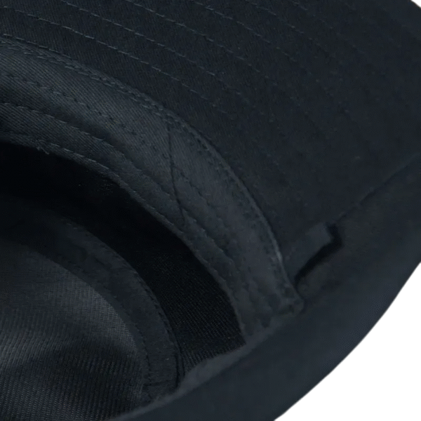 Un bob chapeau noir renversé sur fond blanc