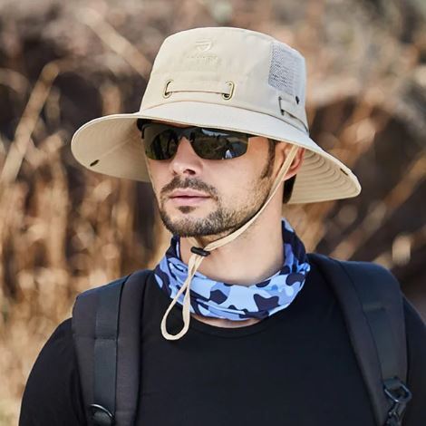 Un pêcheur avec des lunettes noires de soleil porte un joli chapeau bob pêche beige sur la tête sur un décor de nature flouté