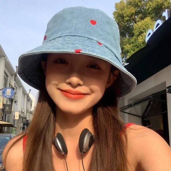 Jeune fille souriante porte un bob chapeau en jean