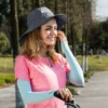 Une femme au téléphone en pleine nature au soleil porte un bob chapeau avec ficelle bleu