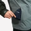 Un homme met un bob chapeau plié dans sa poche de veste