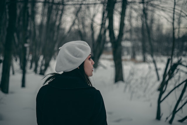 Femme porte un béret dans un paysage enneigé