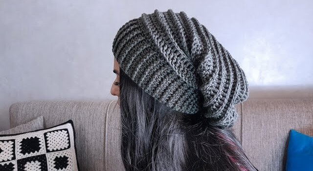 Fille de profil porte un gros bonnet en laine gris
