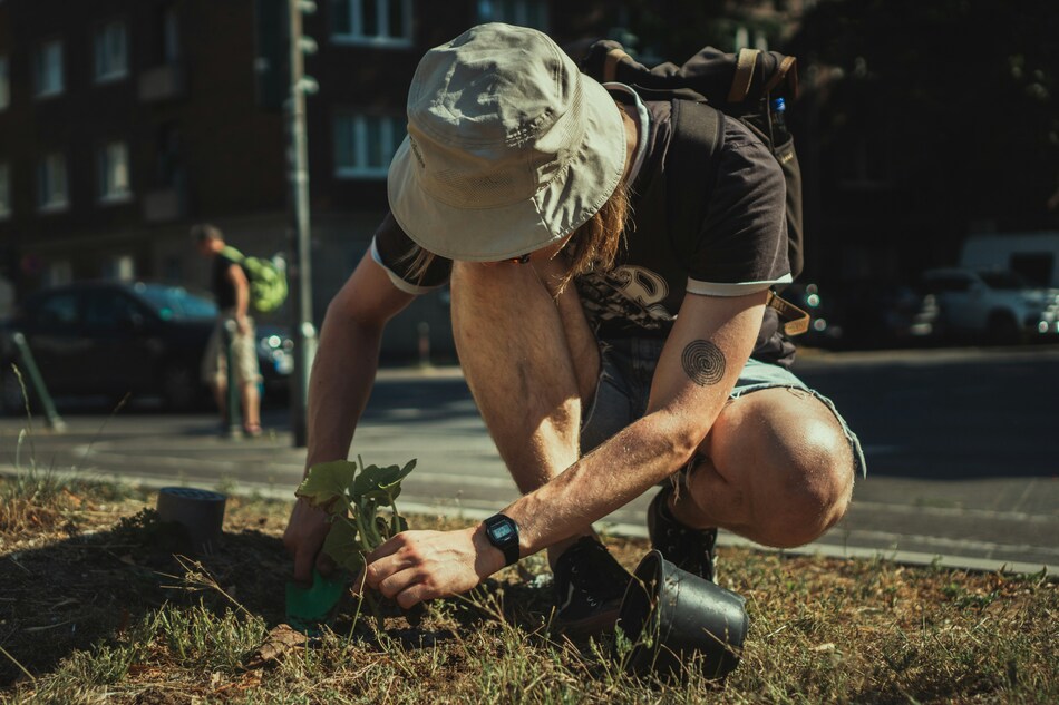 Un homme porte un bob chapeau pour se protéger du soleil pendant sa séance de jardinage