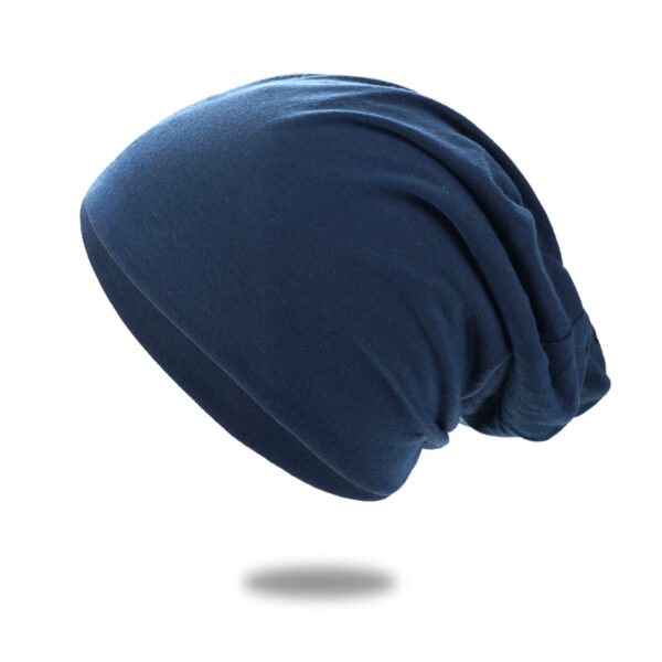 Un bonnet en coton bleu marine est montré sur un fond blanc