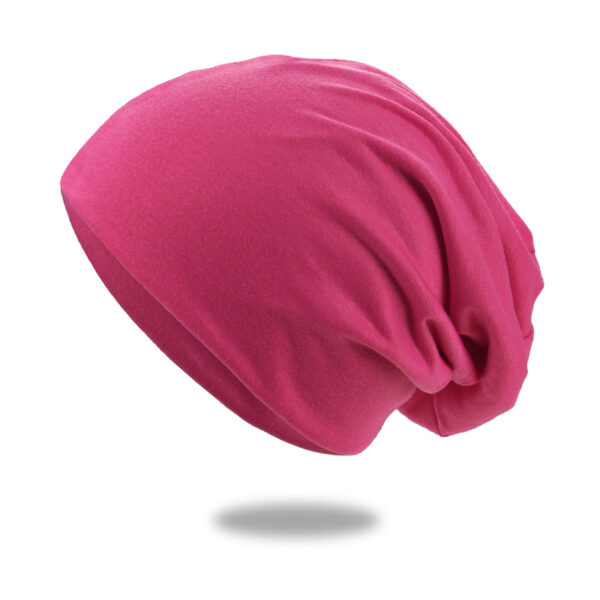 Un bonnet en coton rose est montré sur un fond blanc