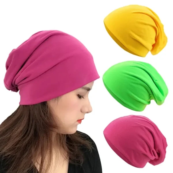 Un modèle féminin de profil porte un bonnet coton rose sur fond balnc avec 3 autres variantes, jaune, vert et rose présentées à côté