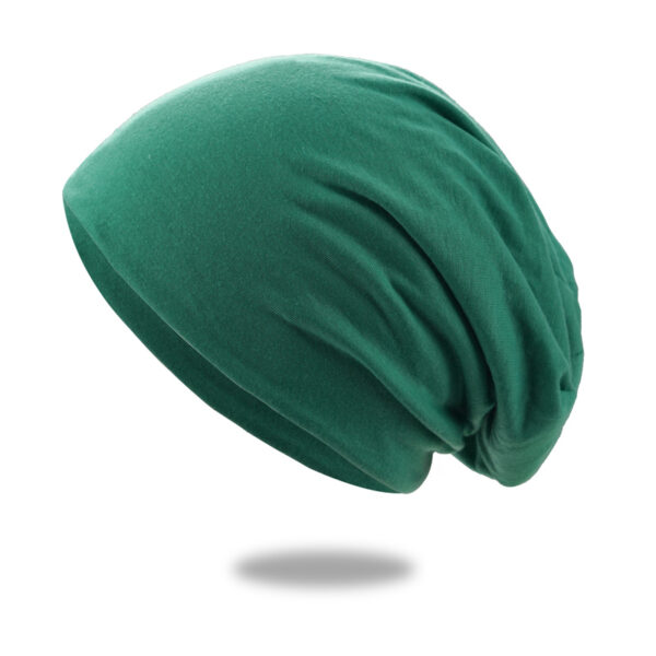 Un bonnet en coton vert est montré sur un fond blanc