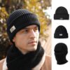 Un homme porte un bonnet cagoule 2 en 1 noir sur un décor de nature