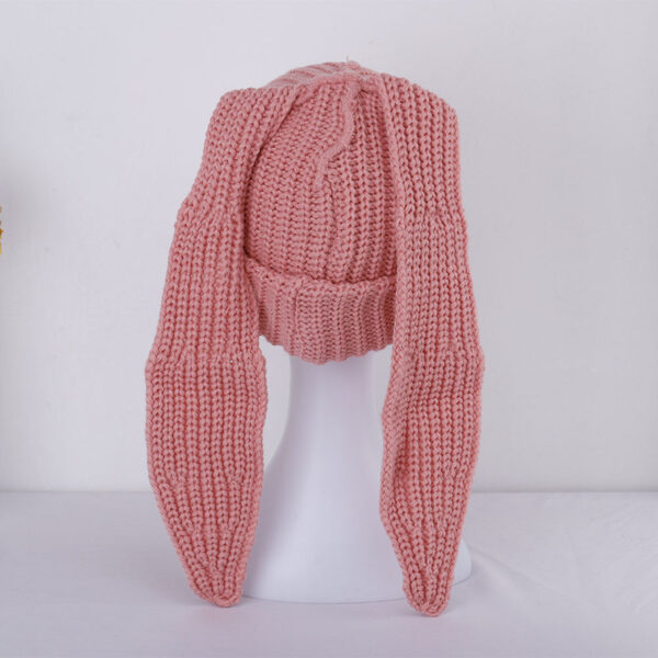 Le bonnet avec oreilles de lapin rose est présenté de dos sur sa tête de mannequin en plastique