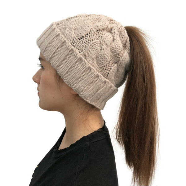 Fille longs cheveux porte un bonnet queue de cheval beige de profil
