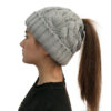 Fille longs cheveux porte un bonnet queue de cheval gris de profil