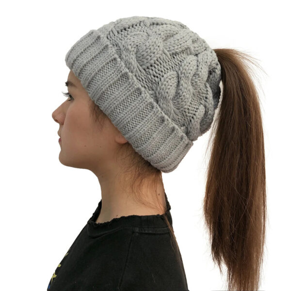 Fille longs cheveux porte un bonnet queue de cheval gris de profil