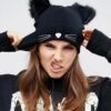 Une fille stylée porte un bonnet avec des oreilles sur fond gris