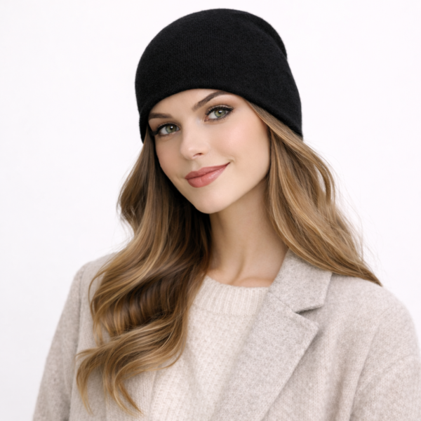 Une femme porte un bonnet en cachemire noir sur un fond clair