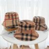 Trois chapeaux bob sont présentés sur une table claire
