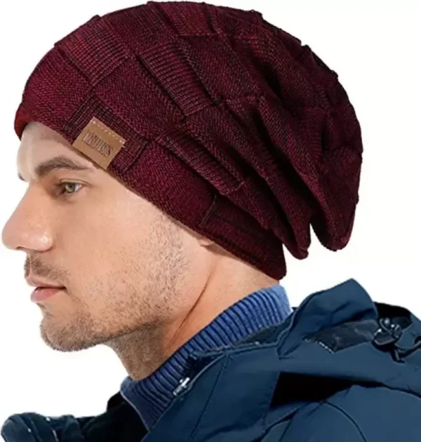 Un homme porte un bonnet bordeaux sur un décor blanc