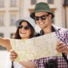 Deux jeunes touristes souriants portent un bob chapeau sous le soleil en ville