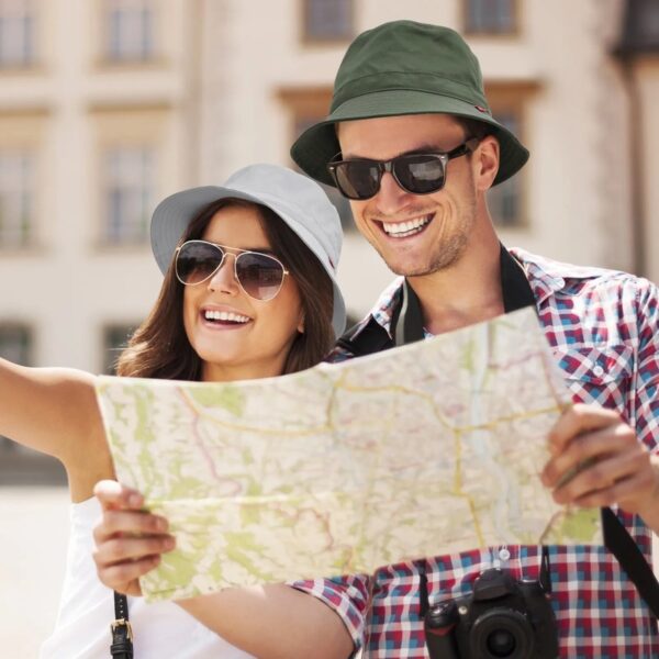 Deux jeunes touristes souriants portent un bob chapeau sous le soleil en ville