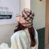 Une femme habillée élégante tournée de dos porte un magnifique chapeau bob style anglais