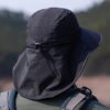 Randonneur de dos porte un bob noir très large pour la protection du soleil