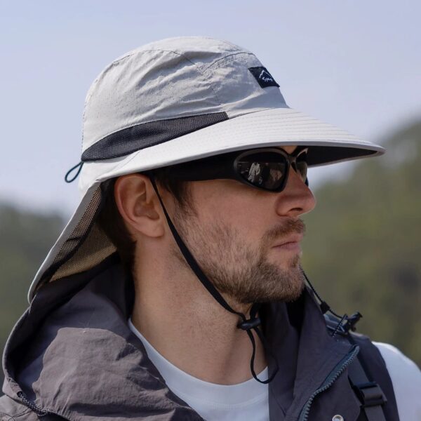 Un randonneur est protégé du soleil grâce à son chapeau de pêcheur et ses lunettes