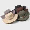 Plusieurs chapeaux sont exposés sur un décor clair