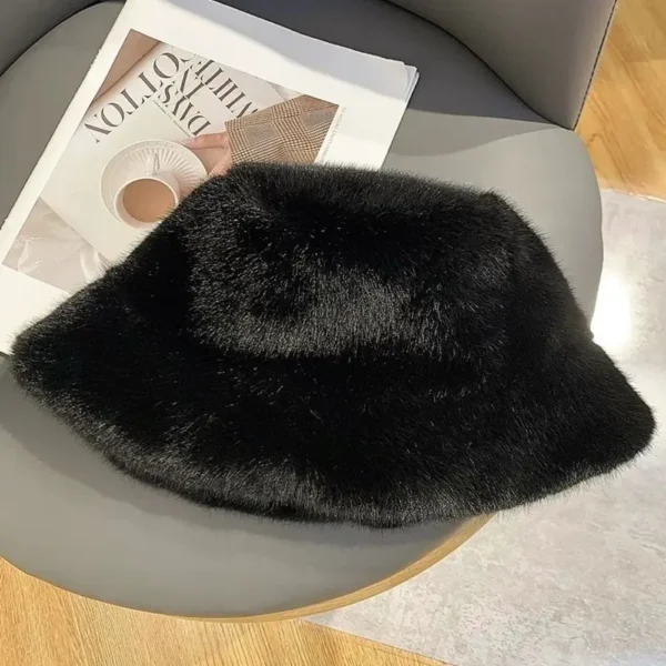 Un bob fourrure noir pour femme est posé à plat sur un siège