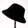 Un bob en fourrure pour les femmes couleur noir présenté sur un porte-chapeau