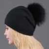 Femme de profil porte un magnifique bonnet à pompon noir