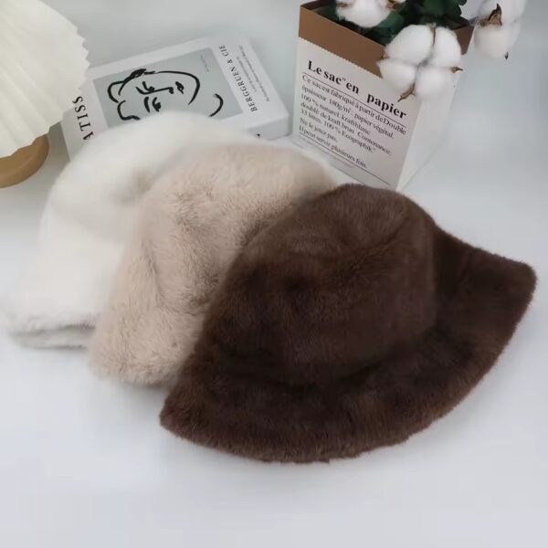 Trois bobs chapeaux à plat les uns sur les autres sont présentés sur un décor gris clair