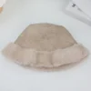Un bob en fourrure synthétique beige est retourné sur lui-même pour nous présenter sa texture intérieure