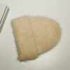 Bonnet alpaga beige avec revers épais, composé de laine duveteuse, conçu pour offrir confort et chaleur pendant l’hiver.