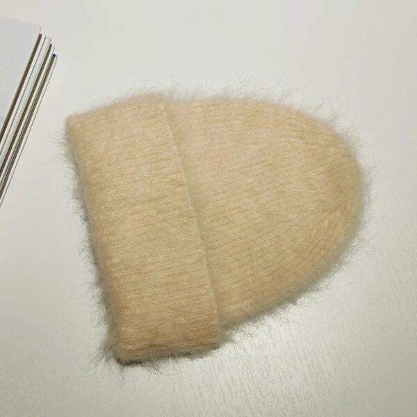 Bonnet alpaga beige avec revers épais, composé de laine duveteuse, conçu pour offrir confort et chaleur pendant l’hiver.