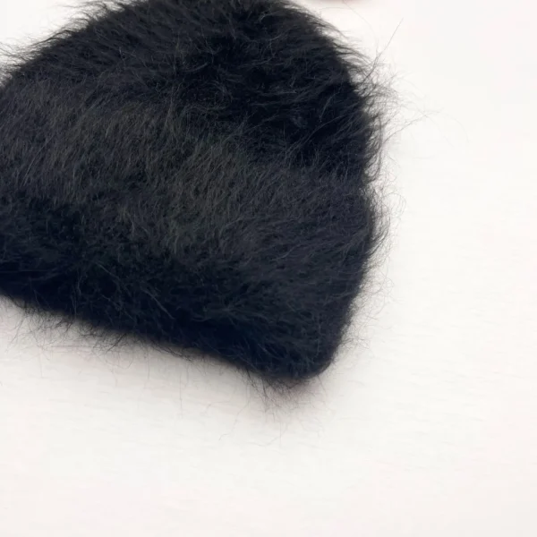 Bonnet en alpaga noir avec texture duveteuse et poil long, offrant une isolation thermique élevée pour protéger du froid hivernal.