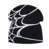 Bonnet de ski pour homme noir avec un motif toile d’araignée blanche, conçu en maille chaude et présenté sur fond blanc pour un style original en hiver.