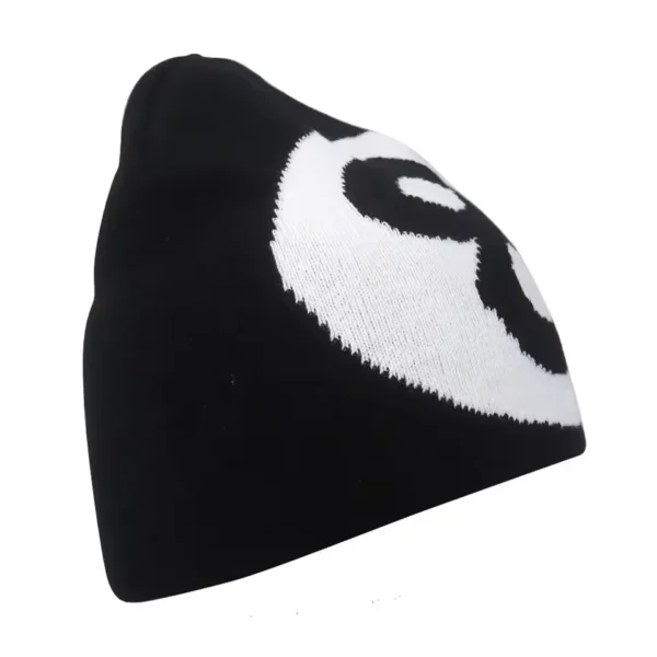 Bonnet de ski pour homme noir avec un motif blanc, photographié de côté, idéal pour rester au chaud tout en affichant un style original.