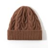 Bonnet d’hiver pour femme en laine marron, tricot torsadé et coupe confortable.
